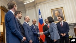 2024年2月22日，台湾总统蔡英文（右二）与访问台湾的美国国会议员握手。右边旁边观看的是美国国会众议院中共问题特设委员会主席麦克·加拉格尔。