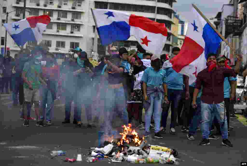 Los manifestantes agitan banderas durante los enfrentamientos con la policía antidisturbios. 