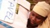 A woman helps load relief supplies onto a truck bound for northern Mali, April 13, 2012. 