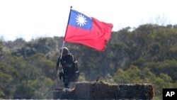 FILE - A soldier holds a Taiwanese flag during a military exercise aimed at repelling an attack from China, Jan. 19, 2021, in Hsinchu County, northern Taiwan.
