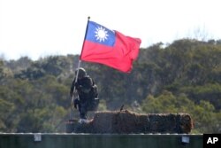FILE - A soldier holds a Taiwanese flag during a military exercise aimed at repelling an attack from China, Jan. 19, 2021, in Hsinchu County, northern Taiwan.