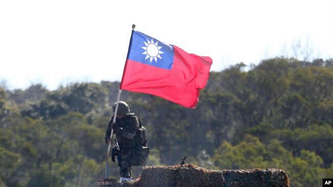 FILE - A soldier holds a Taiwanese flag during a military exercise aimed at defending from an attack from China, Jan. 19, 2021, in Hsinchu County, northern Taiwan.