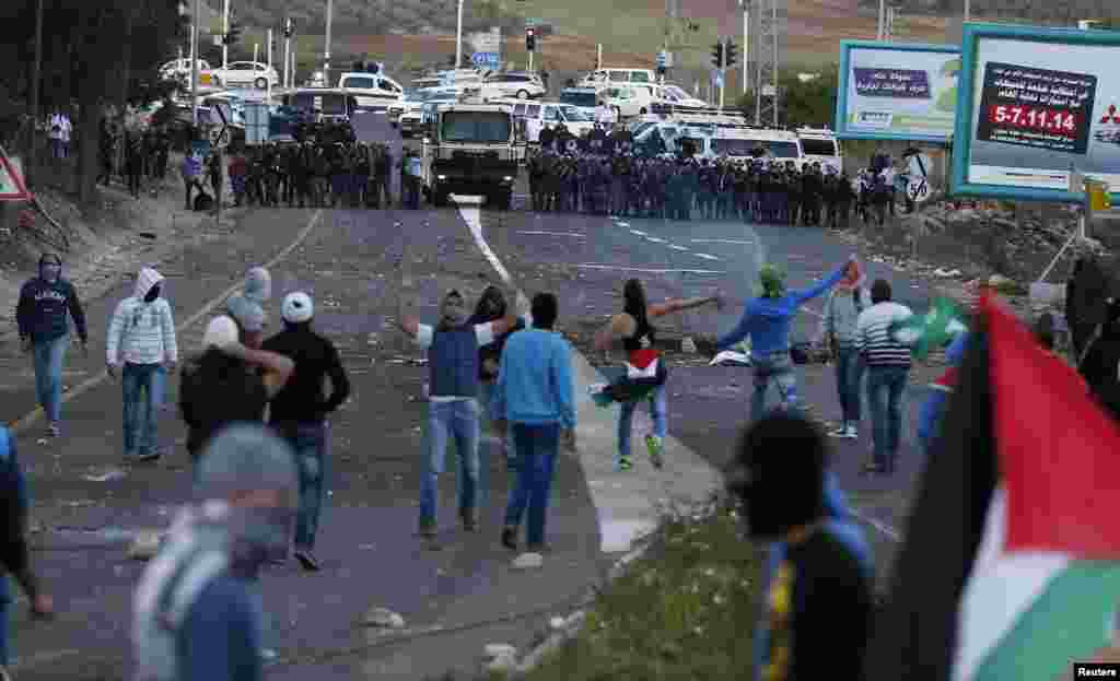 Israeli Arab youths clash with Israeli police at the entrance to the town of Kfar Kanna, northern Israel, Nov. 8, 2014.