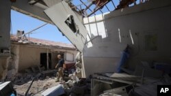 FILE - A man walks through a heavily damaged hospital in the city of Afrin, Syria, June 13, 2021. 