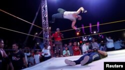 Mohamed Samier, 28, a wrestler nicknamed "El Namer," meaning "Tiger," is seen in action with Androw Tharwat, 27, nicknamed "Malk El Roaab," meaning "King of Horror," during a public fight at the Abu Sultan High School in Ismailiya, northern of Cairo, Egypt, Oct. 26, 2018.