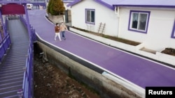 Tourists walk on a purple street at the Purple Island in Shinan, South Korea, March 9, 2021. Picture taken March 9, 2021. REUTERS/Daewoung Kim