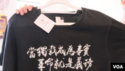 在英國倫敦舉行“抗爭的背後”展覽其中一件展品，一件T恤上印上“當獨裁成爲事實，革命就是義務”的字句。 (美國之音/鄭樂捷)