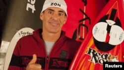 Garrett McNamara of Hawaii is pictured with his winning surf board which he rode in his November 10, 2011, quest, in this photograph released on May 11, 2012.