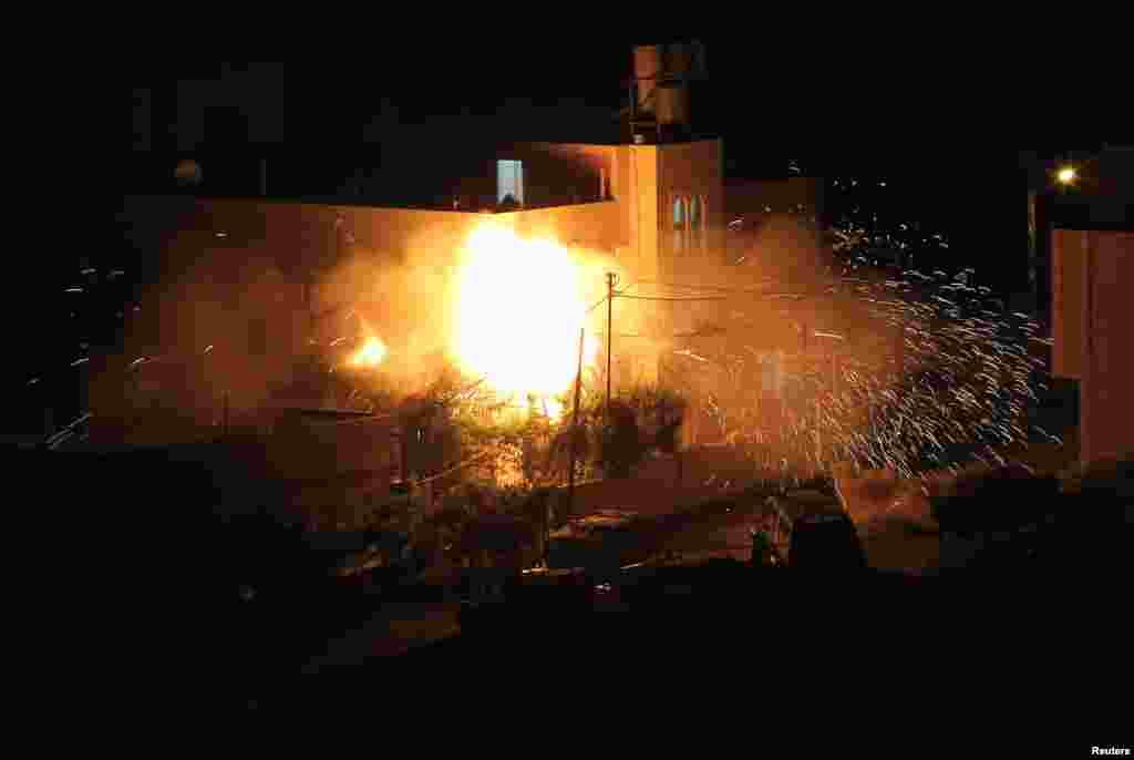 Flames are seen after a blast on the top floor of the family home in Hebron of one of the men Israel accuses of kidnapping three teenagers who were later found dead, July 1, 2014.