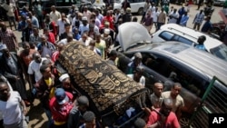FILE - Relatives carry the body of 13-year-old Yassin Moyo for burial, at the Kariakor cemetery in Nairobi, Kenya, March 31, 2020. Police in the capital are accused of shooting him dead while enforcing a coronavirus curfew.