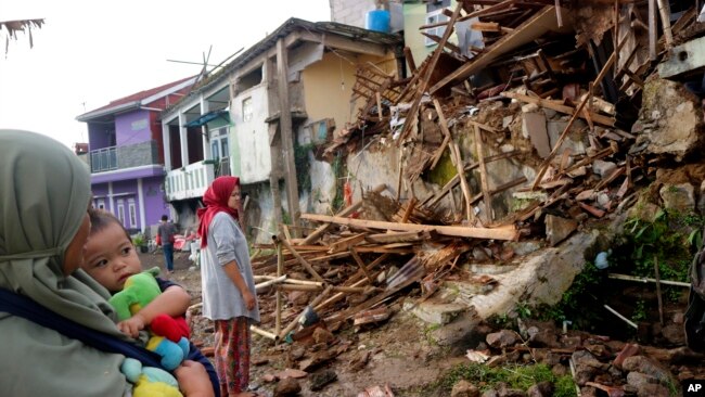 Residents inspect houses damaged by Monday's earthquake in Cianjur, West Java, Indonesia, Nov. 22, 2022.