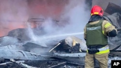 Un bombero trabaja para extinguir un incendio después de un ataque con misiles rusos en Kryvyi Rih, Ucrania, el 8 de enero de 2024. (Servicio de Emergencia de Ucrania vía AP)