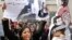 An Egyptian protester chants anti-Interior Ministry slogans as she holds a poster of Shaimaa el-Sabagh, an activist who was shot dead at a peaceful protest last Saturday, with Arabic that reads, "How many martyrs remaining for victory."