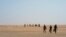 Three men head north towards Algeria after crossing the Assamaka border post in northern Niger, June 3, 2018.