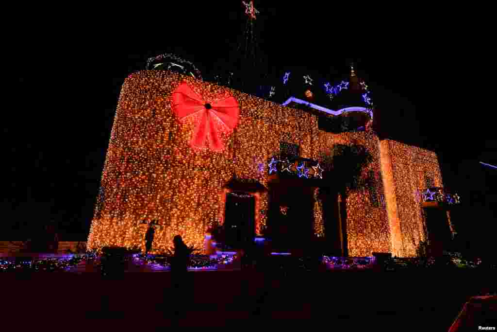 A man walks past a private residence decorated for Christmas with some 57,900 LED lightbulbs on its facade in Mosta, Malta.