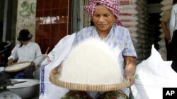 A Cambodian vendor cleans rice at her shop in a roadside market in Phnom Penh, file photo. 