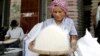 A Cambodian vendor cleans rice at her shop in a roadside market in Phnom Penh, file photo. 