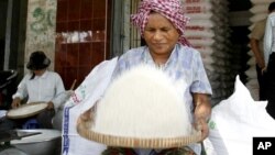 A Cambodian vendor cleans rice at her shop in a roadside market in Phnom Penh, file photo. 