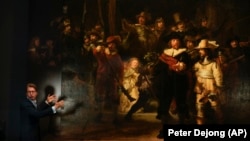 Museum director Taco Dibbits explains how Rembrandt's biggest painting the Night Watch just got bigger with the help of artificial intelligence in Amsterdam, Netherlands, Wednesday, June 23, 2021. (AP Photo/Peter Dejong)