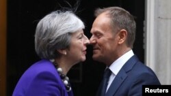 PM Inggris Theresa May (kiri) menyambut kunjungan Presiden Dewan Eropa, Donald Tusk di luar kantornya Downing Street 10, di London, Inggris hari Kamis (1/3). 