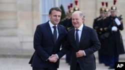 Kancelari gjerman Olaf Scholz shtrëngon duart me Presidentin francez Emmanuel Macron para takimit të udhëheqësve kryesor evropianë në Paris mbi Ukrainën