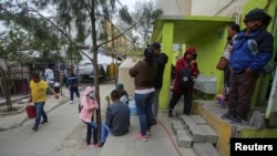 ARCHIVO: Migrantes de diferentes países que solicitaron asilo en EEUU usando la aplicación CBP One esperan por notificaciones de las autoridades de inmigración en Tijuana, México, el 12 de mayo de 203.