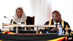 FILE - Speaker of the Parliament of Uganda Anita Among, left, listens to Ugandan President Yoweri Museveni as he delivers an address in Kampala, Uganda, on Feb 14, 2024. The U.S. sanctioned Among and other Ugandan officials on May 30, 2024.