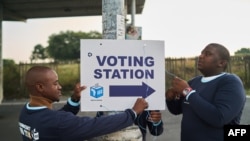Electoral Commission of South Africa (IEC) officials put up a sign outside a polling station in Umlazi on May 29, 2024 during South Africa’s general election.