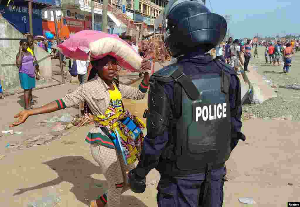 A police officer chases shoppers to clear the streets of the Red Light market on the first day of lockdown to stop the spread of the coronavirus disease (COVID-19) in Monrovia, Liberia, April 11, 2020.