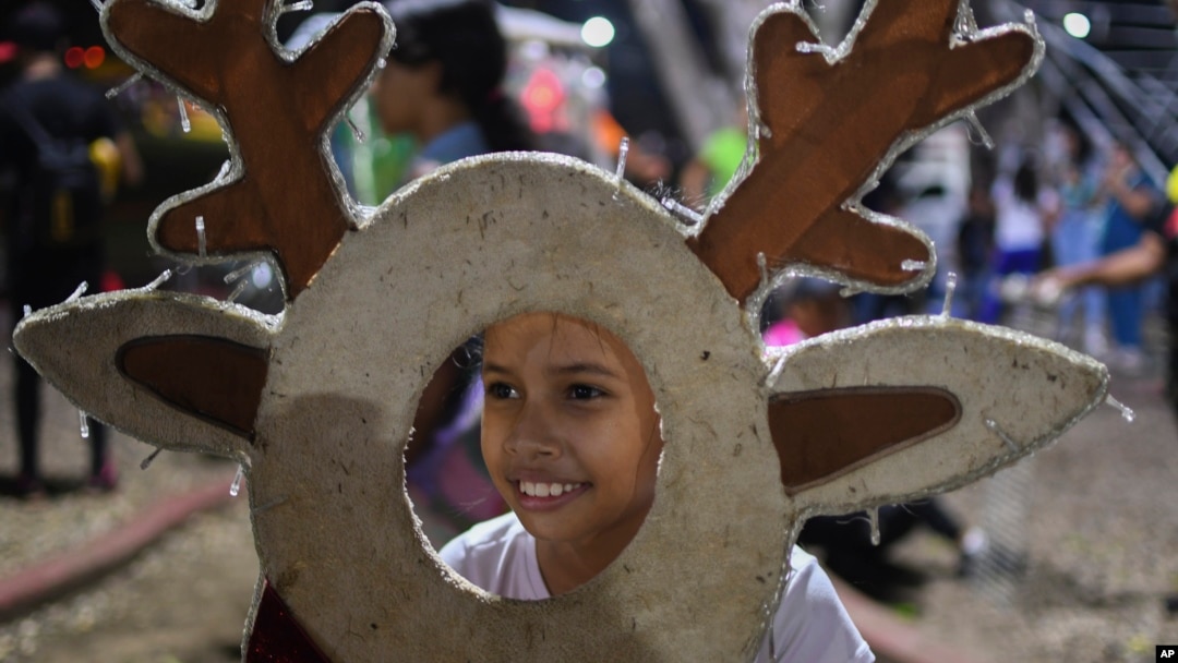A girl poses for a photo with Christmas decorations in Valencia, Venezuela, Oct. 1, 2024. President Nicolas Maduro declared the Christmas season would start earlier this year in the South American country. 