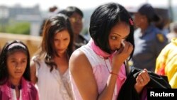 A woman weeps after paying her respects to Nelson Mandela as Mandela lies in state at the Union Buildings in Pretoria, Dec. 12, 2013. 