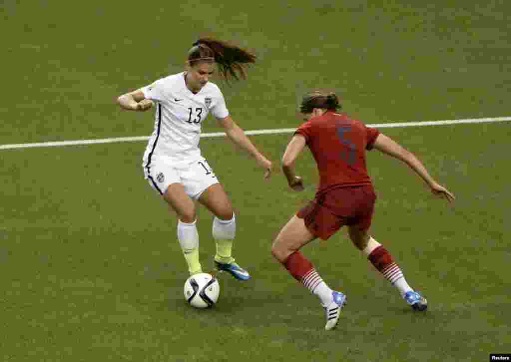 L'attaquante américaine Alex Morgan (13) contrôle la balle face à la défenseur à allemande Annike Krahn (5) au cours de la deuxième moitié de la demi-finale de la Coupe du Monde/Dames 2015 de la FIFA au Stade olympique, le 30 juin 2015 à Montréal, Québec.