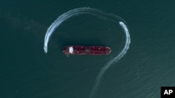 In this July 21, 2019 photo, an aerial view shows a speedboat of Iran's Revolutionary Guard moving around the British-flagged oil tanker Stena Impero which was seized in the Strait of Hormuz by the Guard, in the Iranian port of Bandar Abbas.