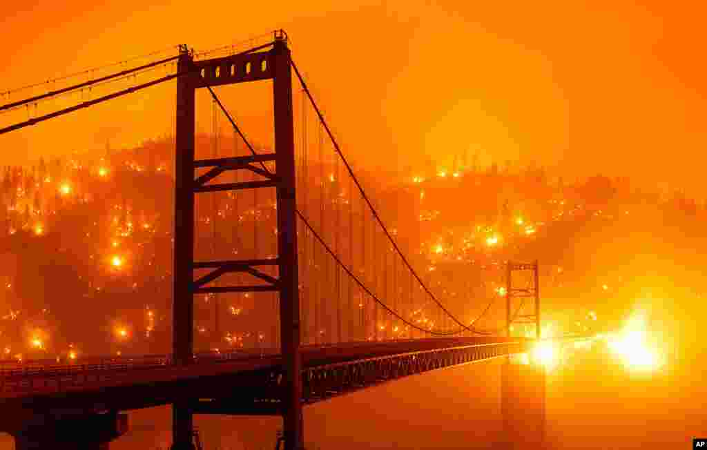 Embers light up a hillside behind the Bidwell Bar Bridge, Sept. 9, 2020, as the Bear Fire burns in Oroville, California.