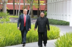 FILE - North Korea's leader Kim Jong Un walks with U.S. President Donald Trump at the Capella Hotel on Sentosa island in Singapore, in this picture taken June 12, 2018, and released from North Korea's Korean Central News Agency.