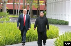 FILE - North Korea's leader Kim Jong Un, right, walks with U.S. President Donald Trump at the Capella Hotel on Sentosa island in Singapore, in this picture taken June 12, 2018, and released from North Korea's Korean Central News Agency.