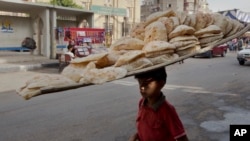 Un vendeur de pain cherche des clients sur un marché dans le quartier de Sayeda Zeinab, au Caire, en Égypte, mardi 14 juin 2016.