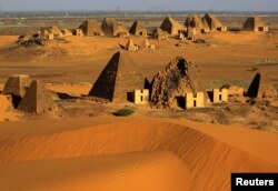 FILE - Creeping desert sands surround the Royal Cemeteries of Meroe Pyramids in Begrawiya at River Nile State, Sudan, Nov. 10, 2019.