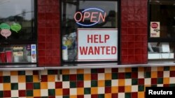 Un aviso en un restaurante de Solana Beach, California, indica que se busca empleados. Julio 17 de 2017.