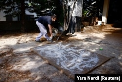 Lebanese artist Charbel Samuel Aoun works on an art piece using dust mixed with resin in Fanar, Lebanon on November 8, 2024. (REUTERS/Yara Nardi)