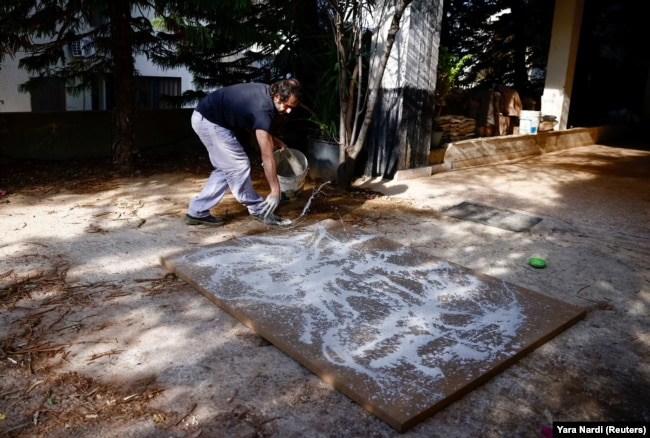 Lebanese artist Charbel Samuel Aoun works on an art piece using dust mixed with resin in Fanar, Lebanon on November 8, 2024. (REUTERS/Yara Nardi)