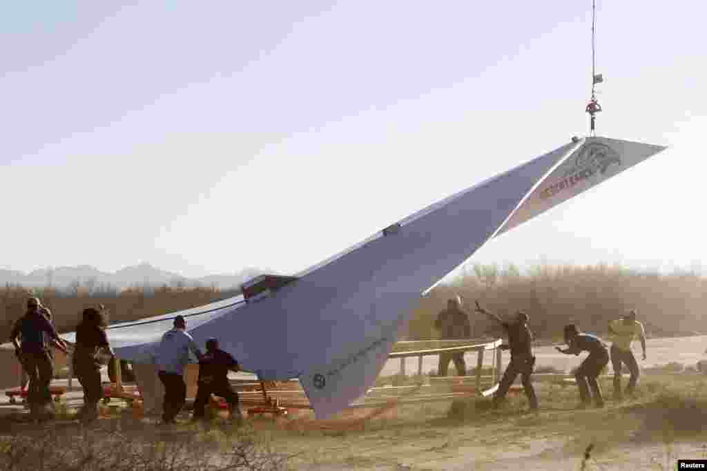 Trabajadores del Museo del Aire y el Espacio de Pima preparan el lanzamiento del avi&oacute;n de papel de casi 14 metros de largo.