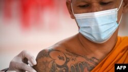 A Buddhist monk receives a dose of China&#39;s Sinovac coronavirus disease (COVID-19) vaccine at a temple in Bangkok, Thailand.