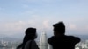 FILE - A couple wearing protective face masks speaks to each other at Kuala Lumpur Tower, amid the coronavirus disease (COVID-19) outbreak, in Kuala Lumpur, Malaysia, July 2, 2020. 