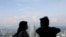 FILE - A couple wearing protective face masks speaks to each other at Kuala Lumpur Tower, amid the coronavirus disease (COVID-19) outbreak, in Kuala Lumpur, Malaysia, July 2, 2020. 
