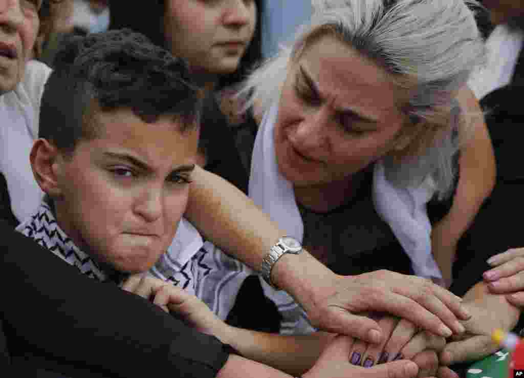 Omar, left, and his mother Lara, attend the Beirut funeral of their father and husband, Alaa Abu Fakher, who was killed by a Lebanese soldier during protests Tuesday night south of the capital.