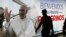 A passenger walks past a poster of Pope Francis at the Tocumen International Airport ahead of Pope Francis' visit for World Youth Day, in Panama City, Panama, Jan. 21, 2019.