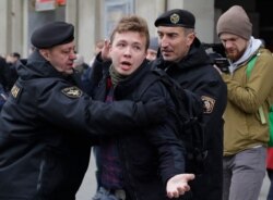 ARCHIVO - En esta imagen del 26 de marzo de 2017, la policía bielorrusa detiene al periodista Raman Pratasevich, en el centro, en Minsk, Bielorrusia.