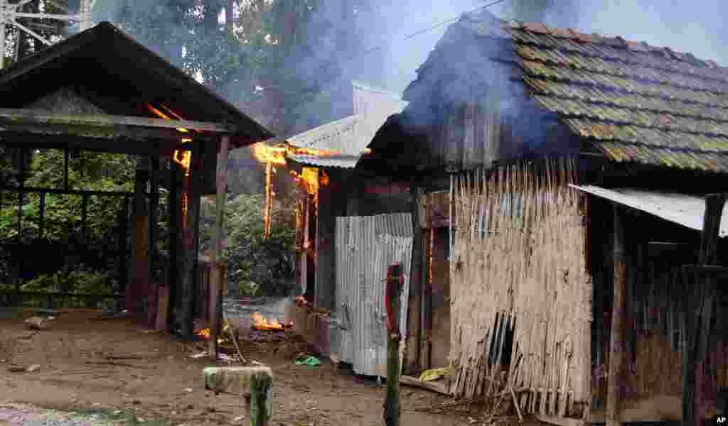 A house burns in Kachugaon village in Kokrajhar, India, July 23, 2012.