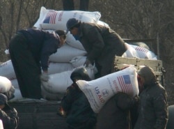 지난 2008년 12월 북한 신의주 주민들이 미국에서 지원한 식량을 트럭에서 내리고 있다. 식량 자루에 'USAID(미국제개발처)' '미국에서 보내온 선물' 이란 문구가 씌여있다. (자료사진)